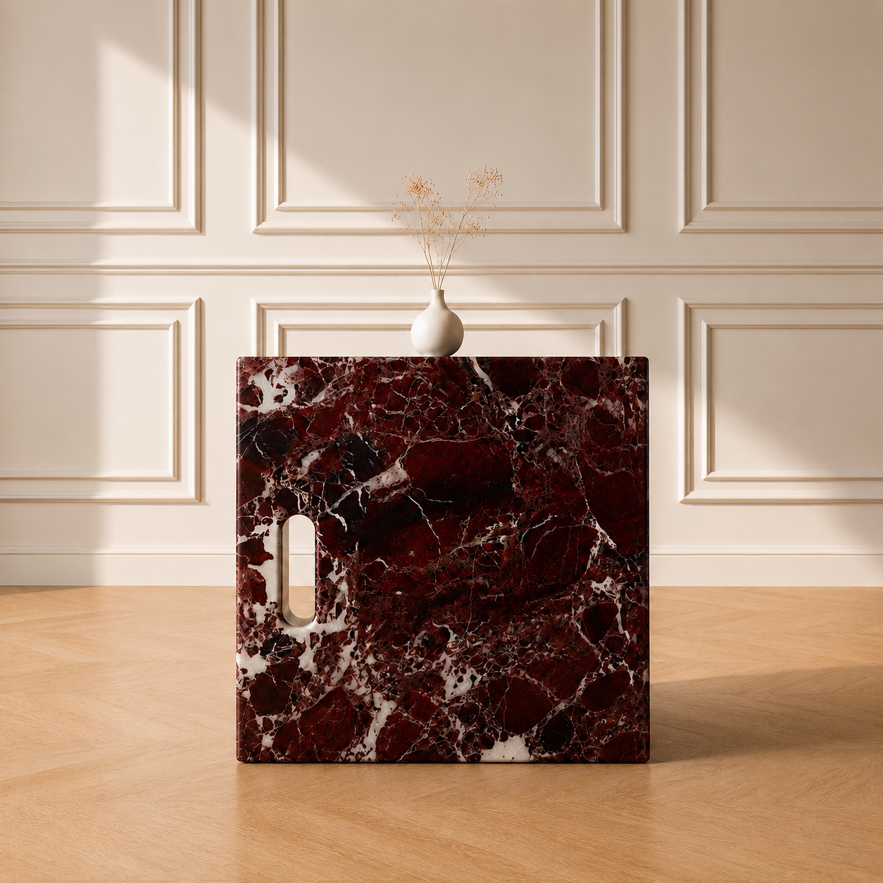 Iéna cube side table in Rosso Levanto marble, styled with a vase against a panelled wall on a chevron wood floor