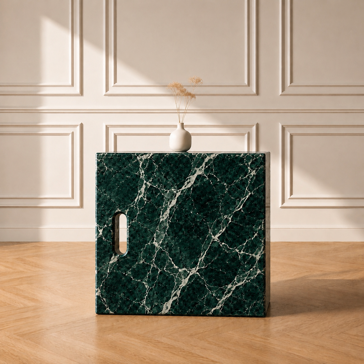 Iéna cube side table in Verde Alpi marble, styled with a vase against a panelled wall on a chevron wood floor