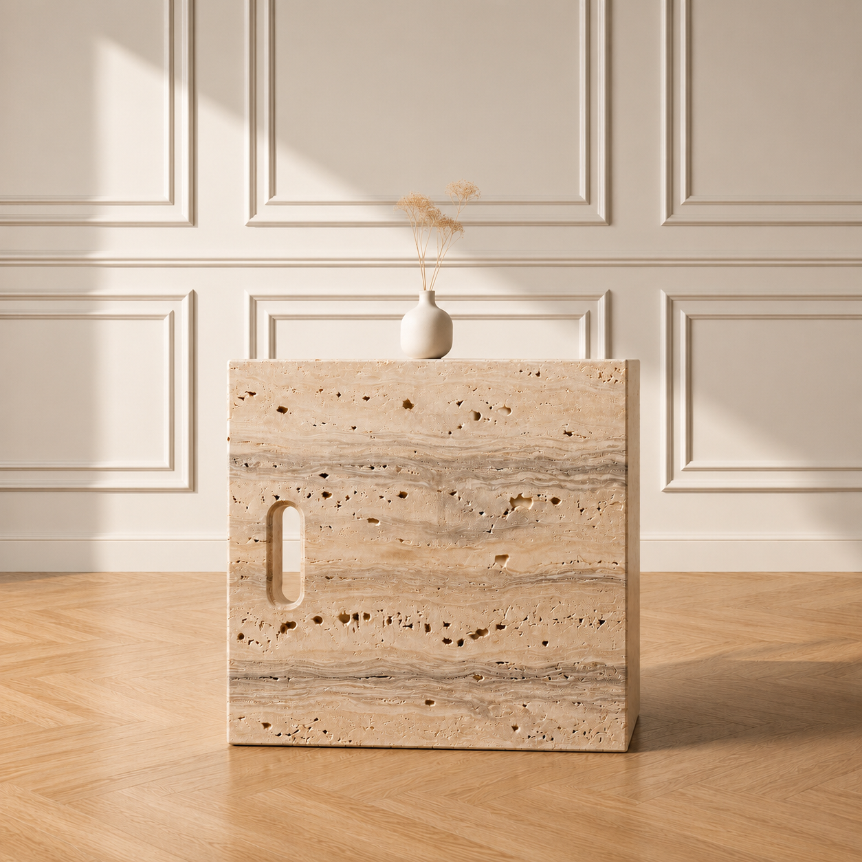 Iéna cube side table in Beige Travertine, styled with a vase against a panelled wall on a chevron wood floor